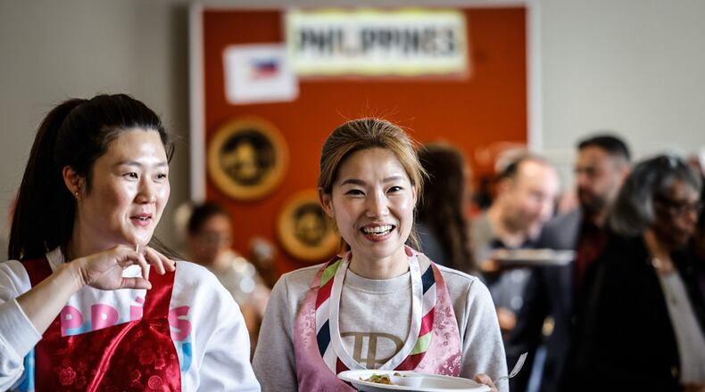 Jiae Kim, left and Kayoung Kim both from South Korea enjoy food at the International Fair held at WPAFB April 26, 2023. The fair is organized by the Wright Patterson International Spouses Group which represents 31 countries from around the globe. JIM NOELKER/STAFF