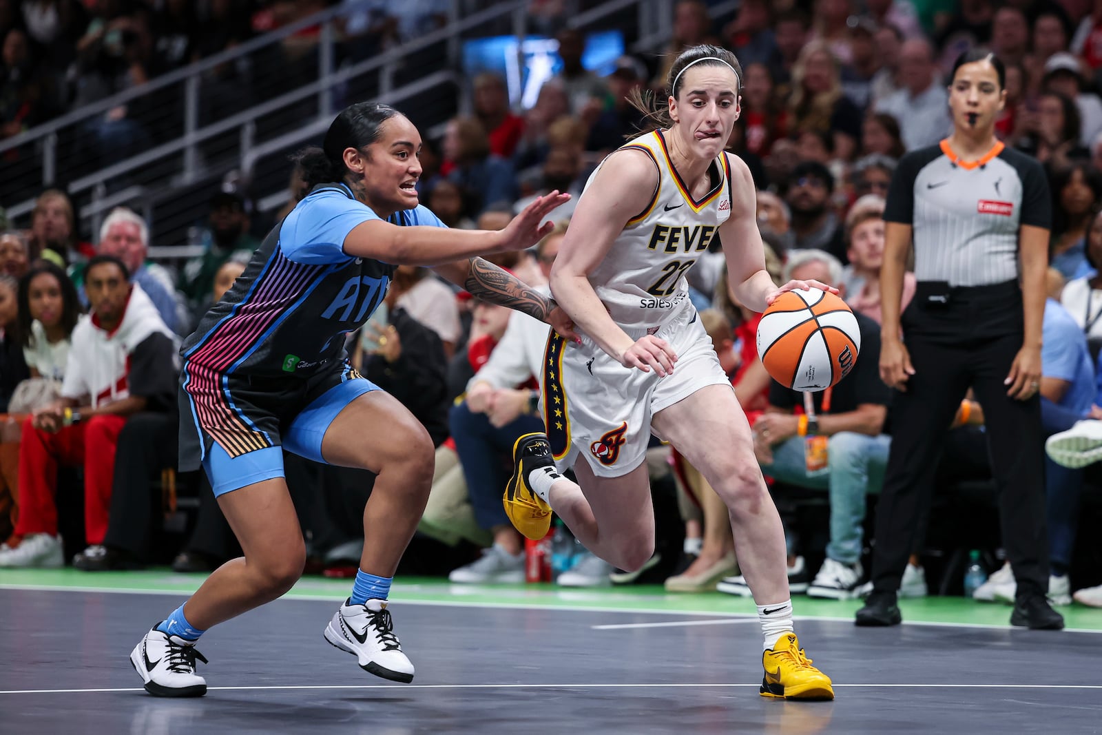 Indiana Fever guard Caitlin Clark (22) drives to the basket against Atlanta Dream guard Te-Hina Paopao, left, in the first half of an WNBA basketball game, Thursday, May, 22, 2025, in Atlanta. (AP Photo/Colin Hubbard)
