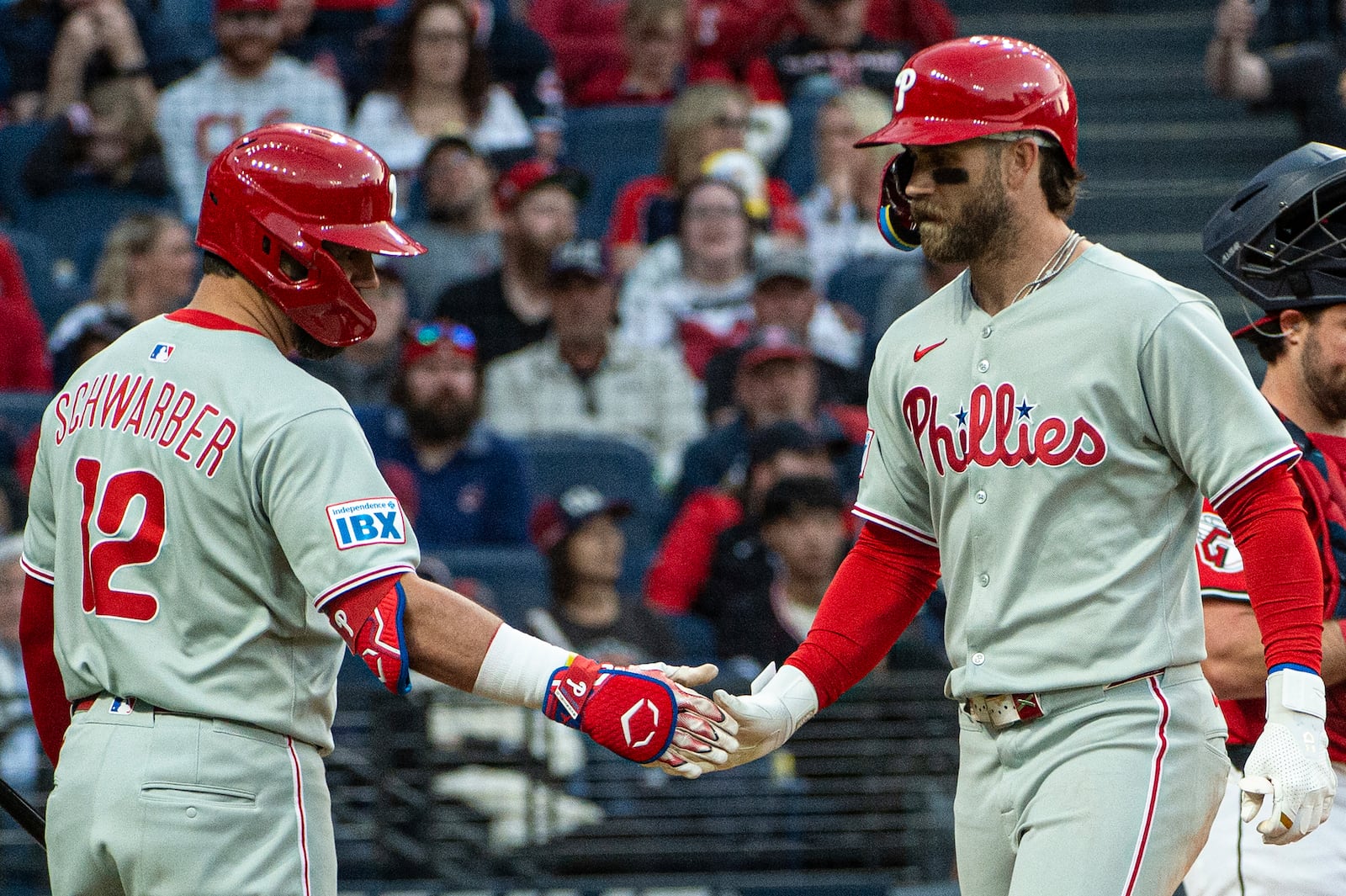 Philadelphia Phillies' Kyle Schwarber (12) congratulates Bryce Harper, right, after Harper's two-run home run off Cleveland Guardians relief pitcher Joey Cantillo during the eighth inning of a baseball game Saturday, May 10, 2025, in Cleveland. (AP Photo/Phil Long)