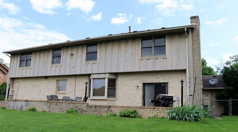 Patio doors off the family room open to a multi-level concrete patio, which is accented by a brick wall. The back yard has a chain-link fence.