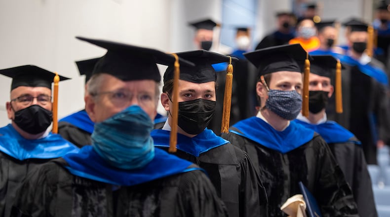 Air Force Capt. Nate Beveridge (center) rises with his classmates at the end of the Air Force Institute of Technology’s Graduate School of Engineering and Management commencement ceremony Sept. 16 at Wright-Patterson Air Force Base. Beveridge’s dissertation was titled “Deep Learning for Weather Clustering and Forecasting.” U.S. AIR FORCE PHOTO/R.J. ORIEZ