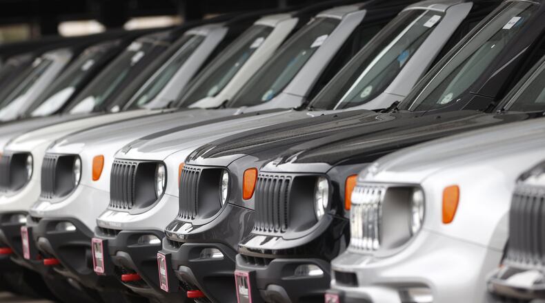 In this Sunday, April 26, 2020, photograph, a long row of unsold 2020 Renegades sits at a Chrysler/Jeep dealership in Englewood, Colo. Edmunds analysts had anticipated more than a million leased vehicles coming back to car dealerships this quarter. But due to countless shelter-in-place orders due to coronavirus concerns, many people will face the question of how to safely handle their vehicle’s lease return or whether they can return their vehicle at all. (AP Photo/David Zalubowski)