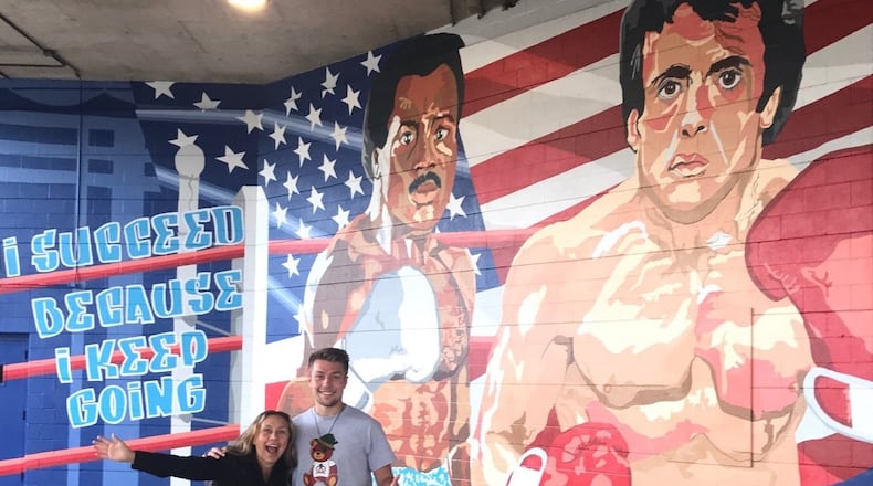 Jerri Stanard, founder/owner of K12 Gallery & TEJAS and her son, UD Student and Flyers boxer Jackson Stanard, the artist who drew the mural and did much of the work putting it on wall at Drake’s Downtown Gym. He’s one of the members of the newly formed UD boxing team. Tom Archdeacon/CONTRIBUTED