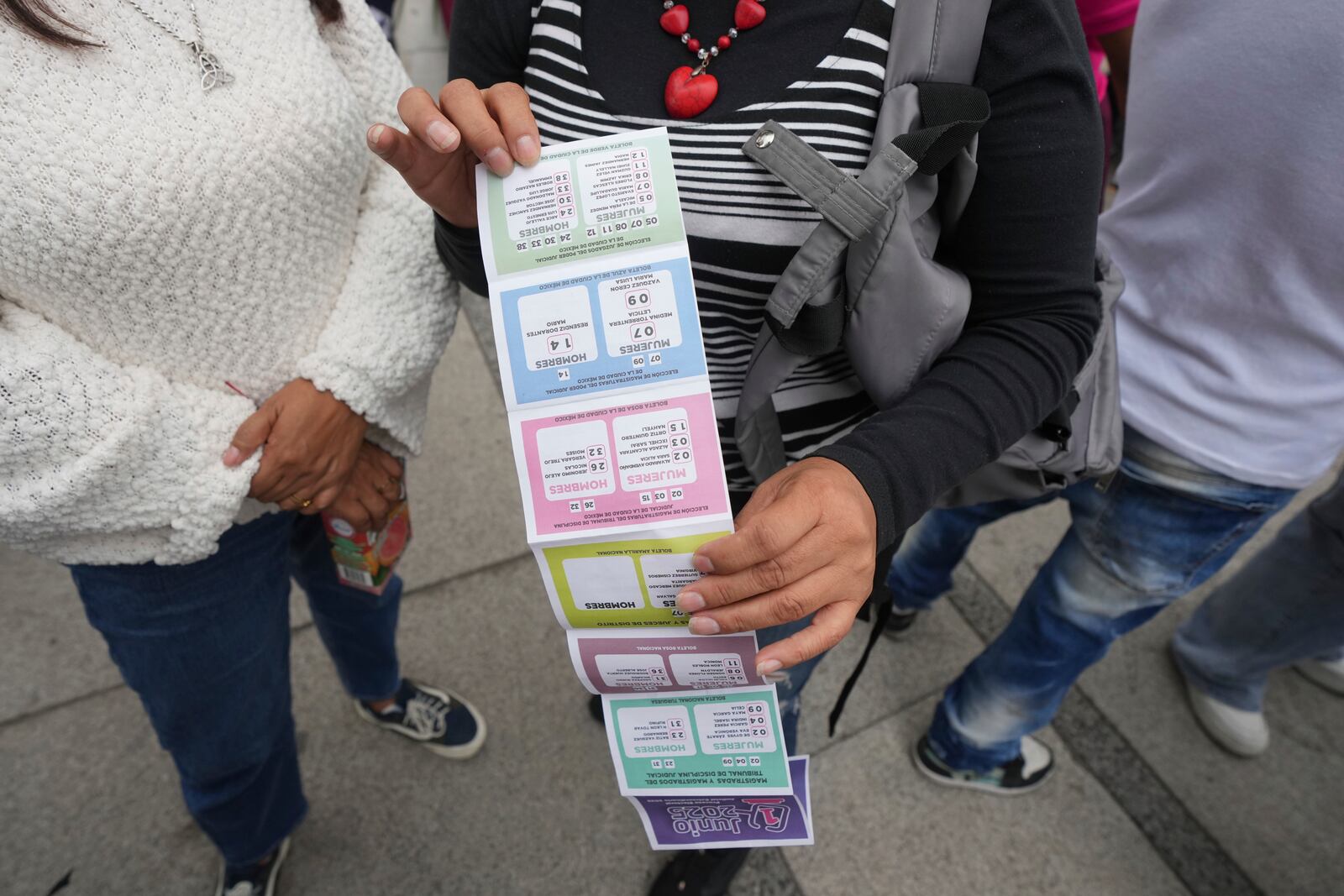 A supporter of Lenia Batres, who is running for election for the Mexican Supreme Court, holds an instruction sheet on how to vote, during her closing campaign rally in Mexico City, Wednesday, May 28, 2025. (AP Photo/Fernando Llano)