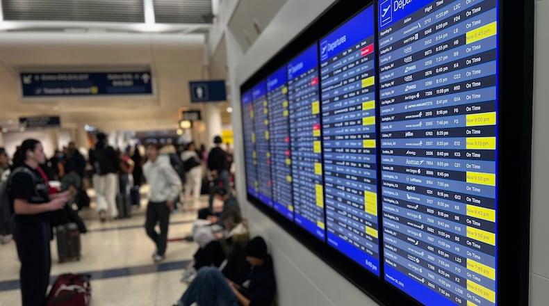 A departure board lists delayed and cancelled flights at O'Hare International Airport, Sunday, Nov. 30, 2025, in Chicago. (AP Photo/Adam Schreck)