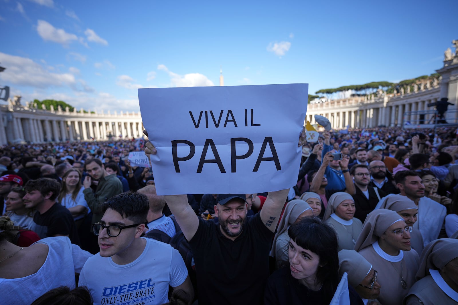 Faithful hold a banner reading "Up with the pope", after white smoke billows from the chimney of the Sistine Chapel during the conclave to elect a new pope, at the Vatican, Thursday, May 8, 2025. (AP Photo/Andrew Medichini)