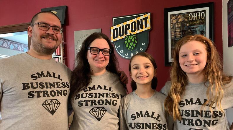 Sara Stathes owns Barrel House in downtown Dayton with her husband, Gus. She is in the center next to daughters and Ellie and Dylan.