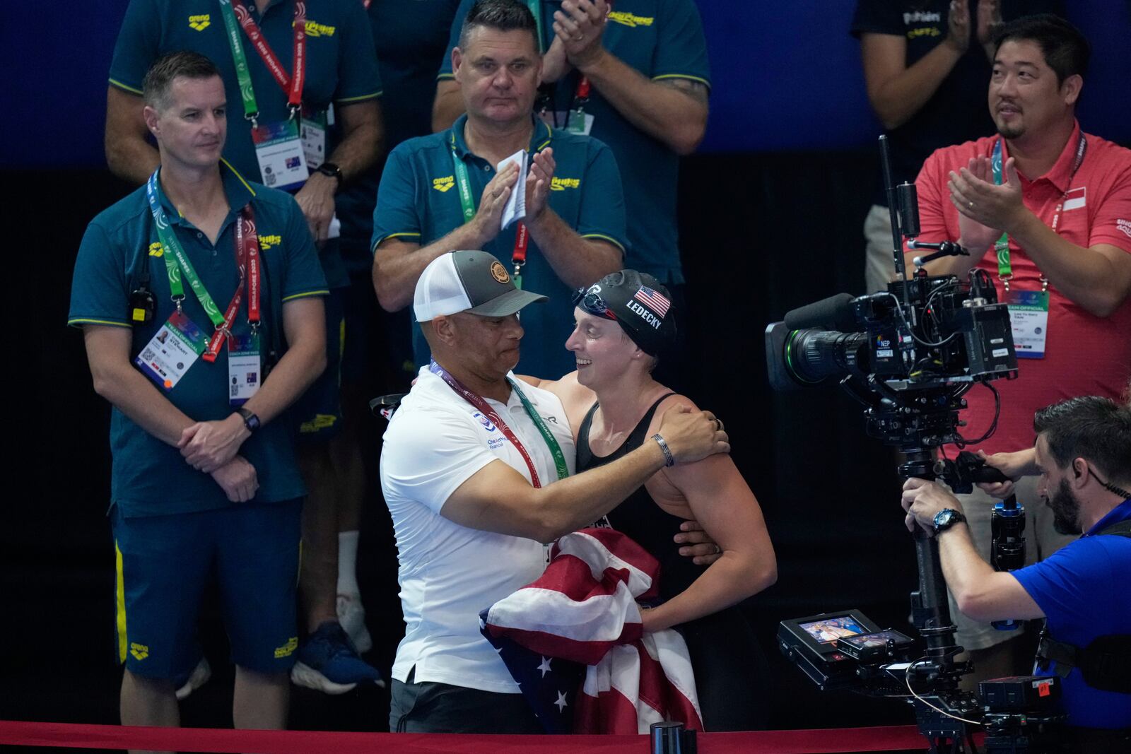 Katie Ledecky of the United States, right, celebrates with her coach Anthony Nesty after winning gold medal in the women's 1500m freestyle final at the World Aquatics Championships in Singapore, Tuesday, July 29, 2025. (AP Photo/Lee Jin-man)