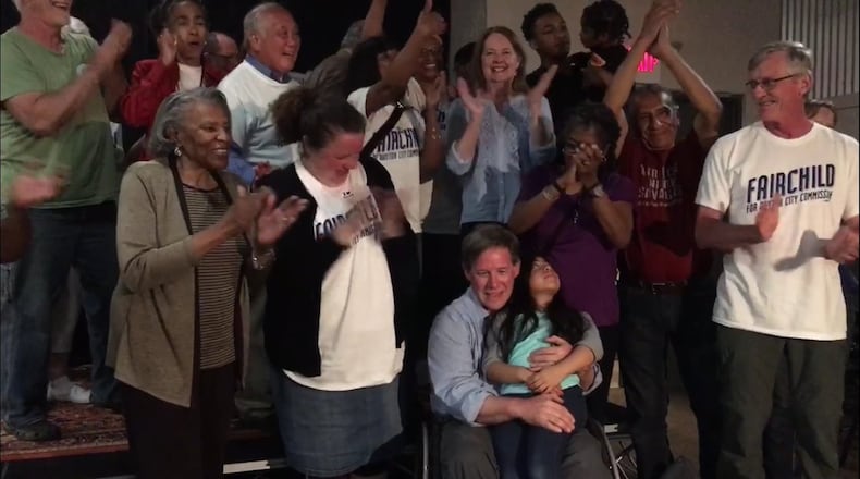 Darryl Fairchild holds his daughter, Maya, on Tuesday night as supporters celebrate Fairchild winning a seat on Dayton City Commission. JEREMY P. KELLEY / STAFF