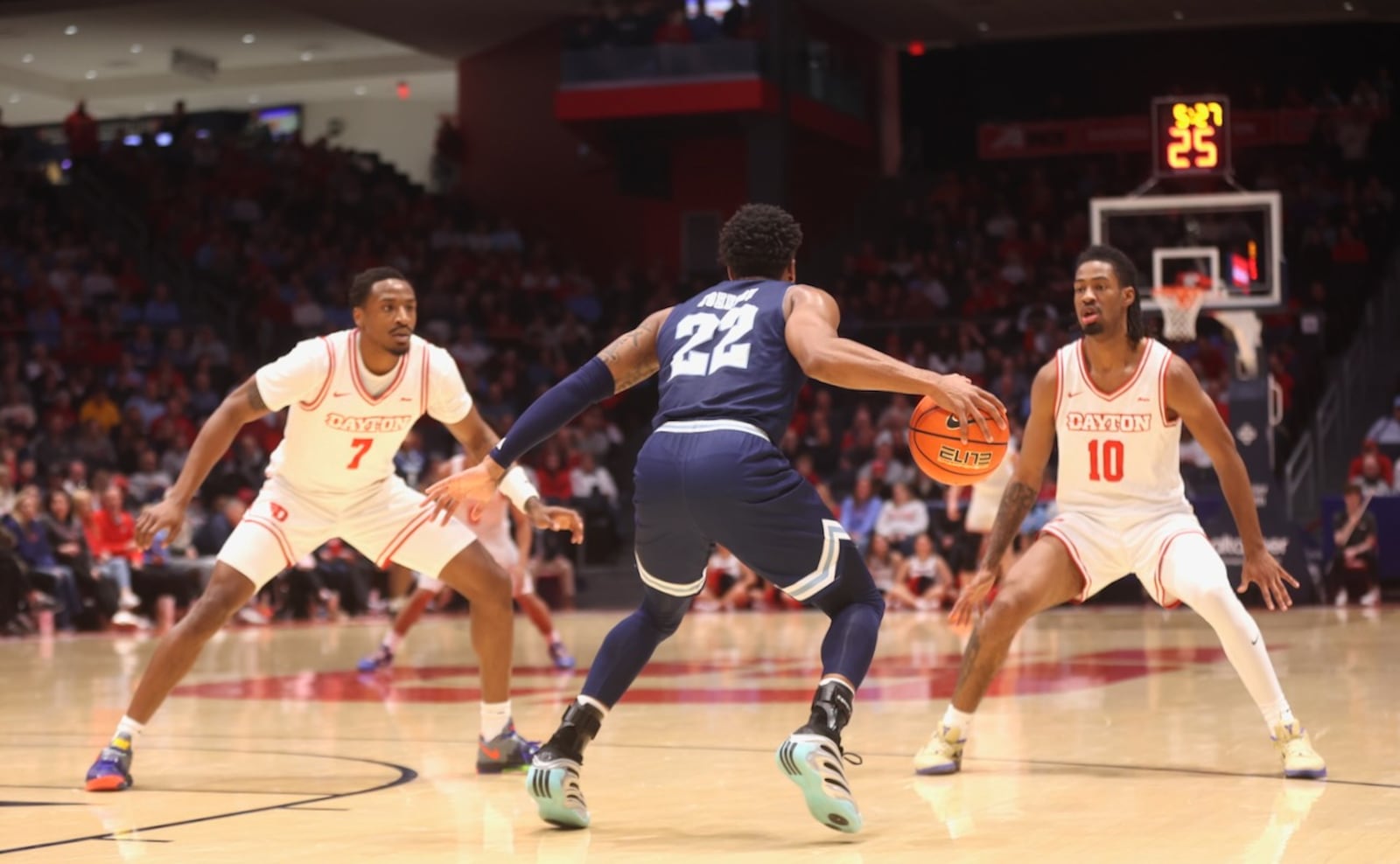 Dayton's Keonte Jones, left, and Bryce Heard, right, trap Rhode Island's RJ Johnson in the first half on Tuesday, Jan. 27, 2026, at UD Arena. David Jablonski/Staff