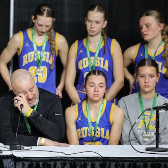 Russia coach Michael Bashore talks while players listen during a postgame news conference following a 38-17 loss to Strasburg-Franklin in the Division VII state final on Saturday, March 14 at University of Dayton Arena. BRYANT BILLING / STAFF
