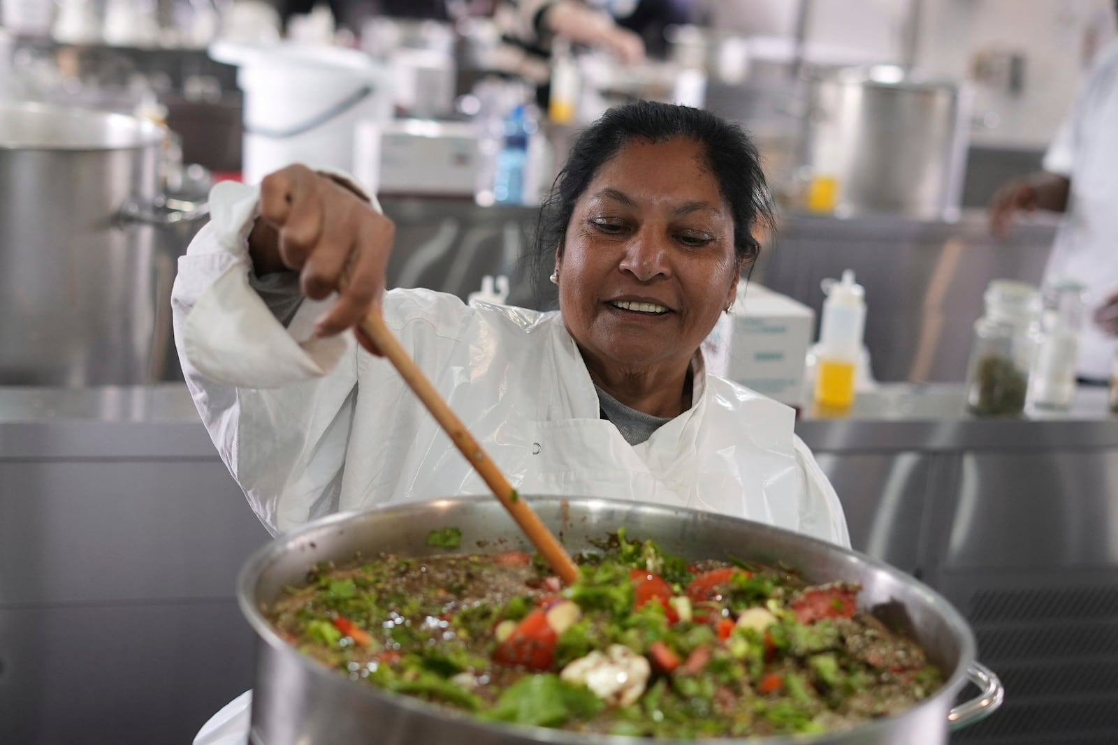 A woman from a local charity steering a pot with nutritional, as chefs, caterers, and culinary students joined forces to whip together 67,000 litres of soup in celebration of Nelson Mandela Day in Johannesburg, South Africa, Friday, July 18, 2025. (AP Photo/Alfonso Nqunjana)