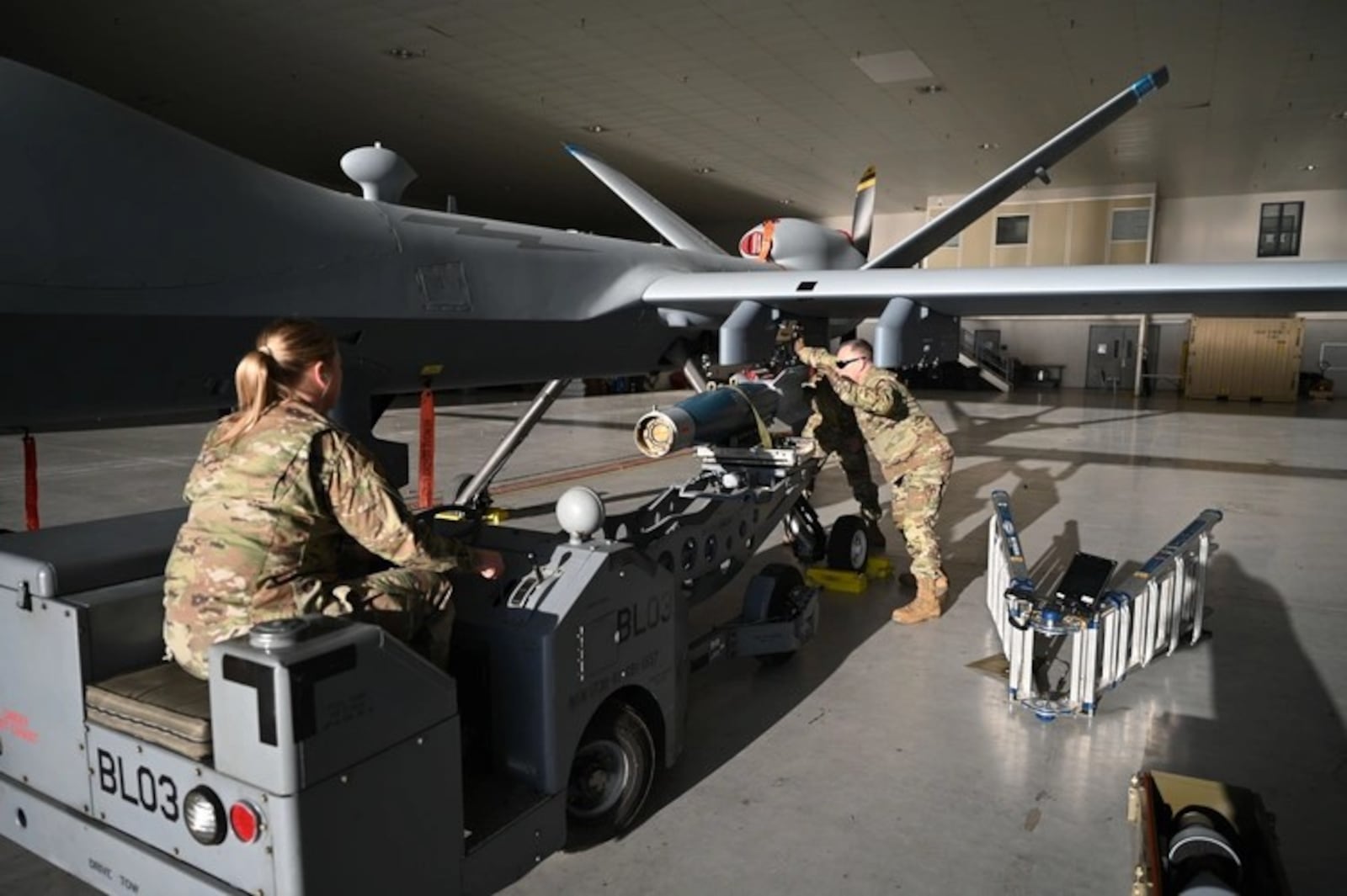 Air Force Tech. Sgt. Rachel Harmon and Mast Sgt. Tom Anderson, weapons loaders assigned to the 174th Attack Wing, checks an inert GBU 12 laser guided missile on an MQ-9 Reaper at Springfield-Beckley Air National Guard Base in Springfield on March 18, 2025. Air National Guard photo by SrA Colin Simpson