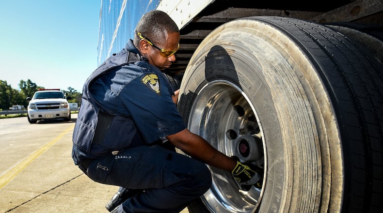 Ohio State Highway Patrol Motor Carrier Enforcement officer Thomas Hays performs a safety inspection Sept. 13 on a semi-truck at the rest area just south of the Monroe exit on southbound I-75 in Liberty Twp.