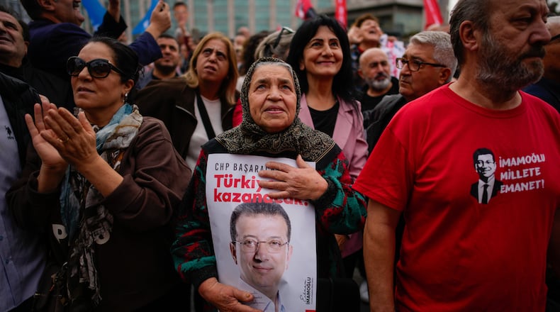 People listen to speeches during a rally in support of Istanbul's imprisoned opposition Mayor Ekrem Imamoglu as he appears for a hearing at the Caglayan courthouse, in Istanbul, Turkey, Sunday, Oct. 26, 2025. The poster with the photo of Imamoglu reads in Turkish: "Turkey will win". (AP Photo/Emrah Gurel)