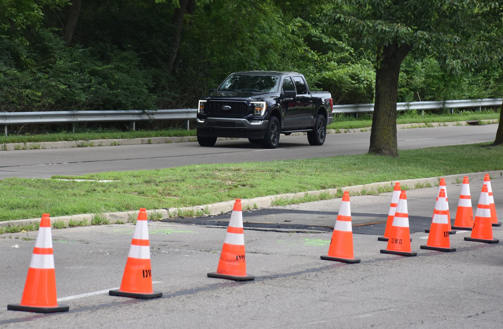 A sinkhole developed on Riverside Drive in north Dayton, which has led to the closure of one of the southbound lanes. CORNELIUS FROLIK / STAFF