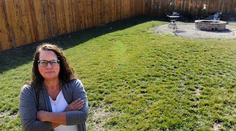 Missie Miller of Carlisle, is organizing an effort to stop Duke Energy from enforcing utility easements along its transmission lines in Carlisle. Miller stands where the easement goes into her yard. MARSHALL GORBY\STAFF