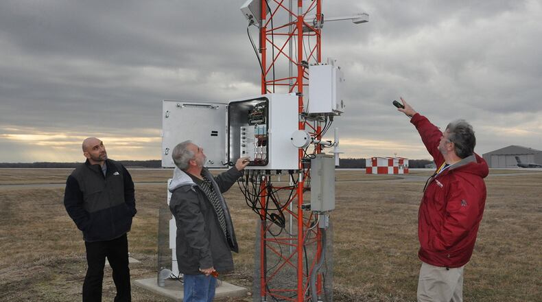 Meteorologist Scott Lutz (from left), Electronics Technician Marvin Mullins and Forecaster Brent Sullins, all personnel in the 88th Operations Support Squadron who keep the weather station at Wright-Patterson Air Force Base up and running, discuss the capabilities of the FMQ19, an automated weather observing system located on the base flight line. (U.S. Air Force photo/Gina Marie Giardina)