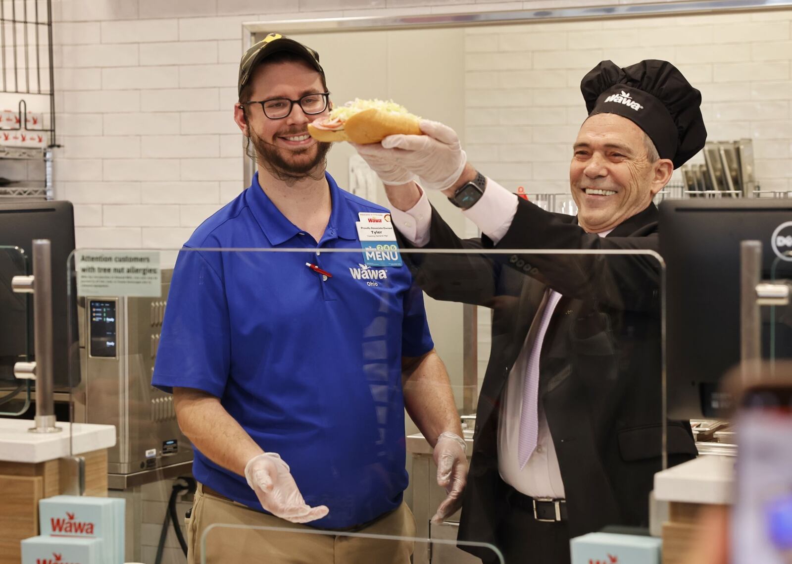 General manager Tyler Morrow, left, and Liberty Township Board of Trustees President Tom Ferrell make the first hoagie at a VIP event Tuesday, April 15, 2025 for Ohio's first Wawa on Cincinnati Dayton Road in Liberty Township. The grand opening is Wednesday. NICK GRAHAM/STAFF