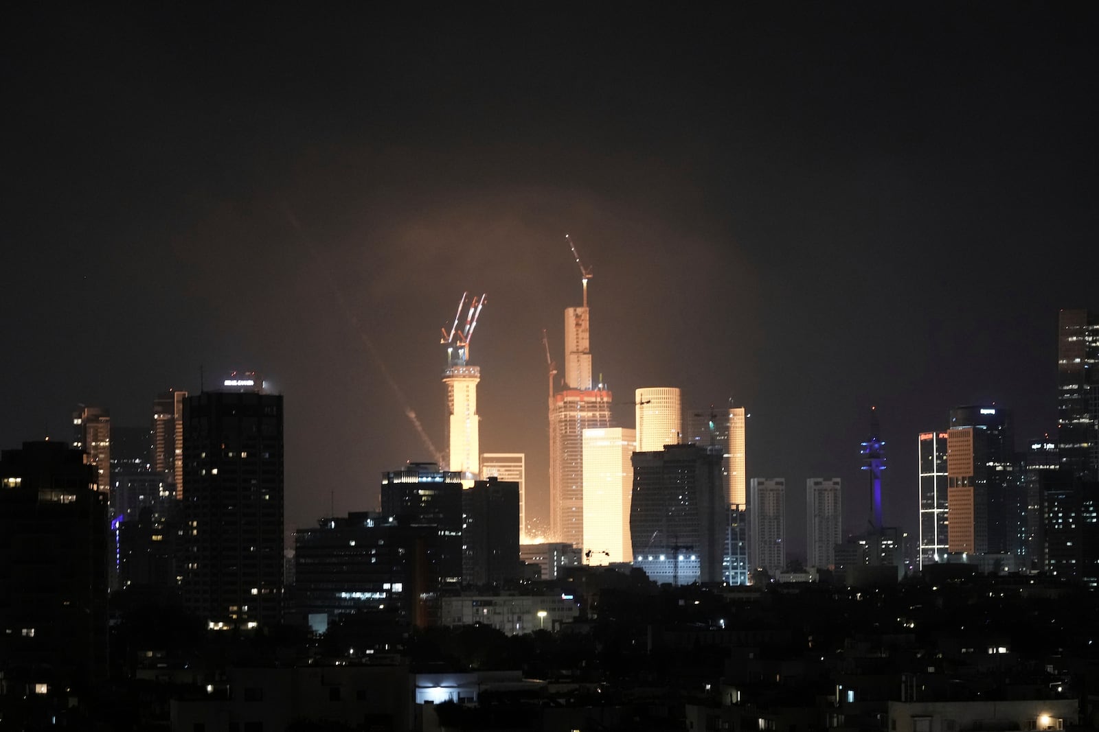 A projectile hits buildings in Tel Aviv, Israel, early Saturday, June 14, 2025. (AP Photo/Leo Correa)