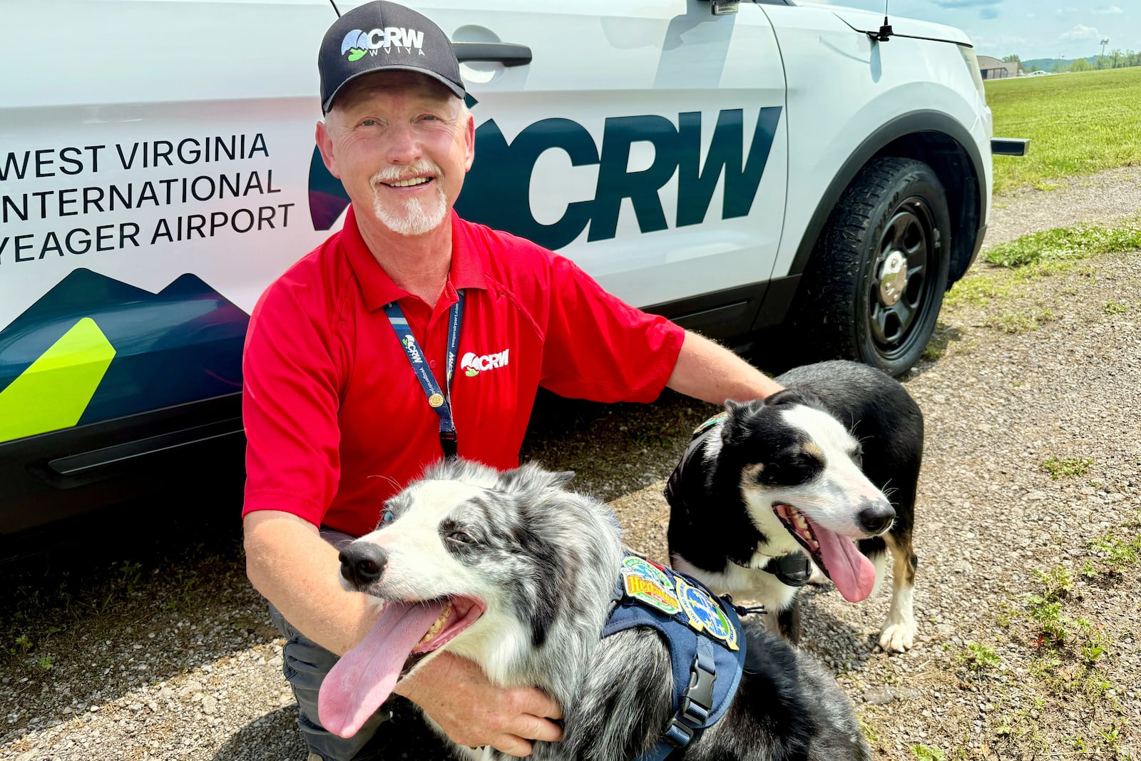 West Virginia International Yeager Airport wildlife specialist and dog handler Chris Keyser poses with Hercules and Ned at the airport in Charleston, W.Va. (AP Photo/John Raby)