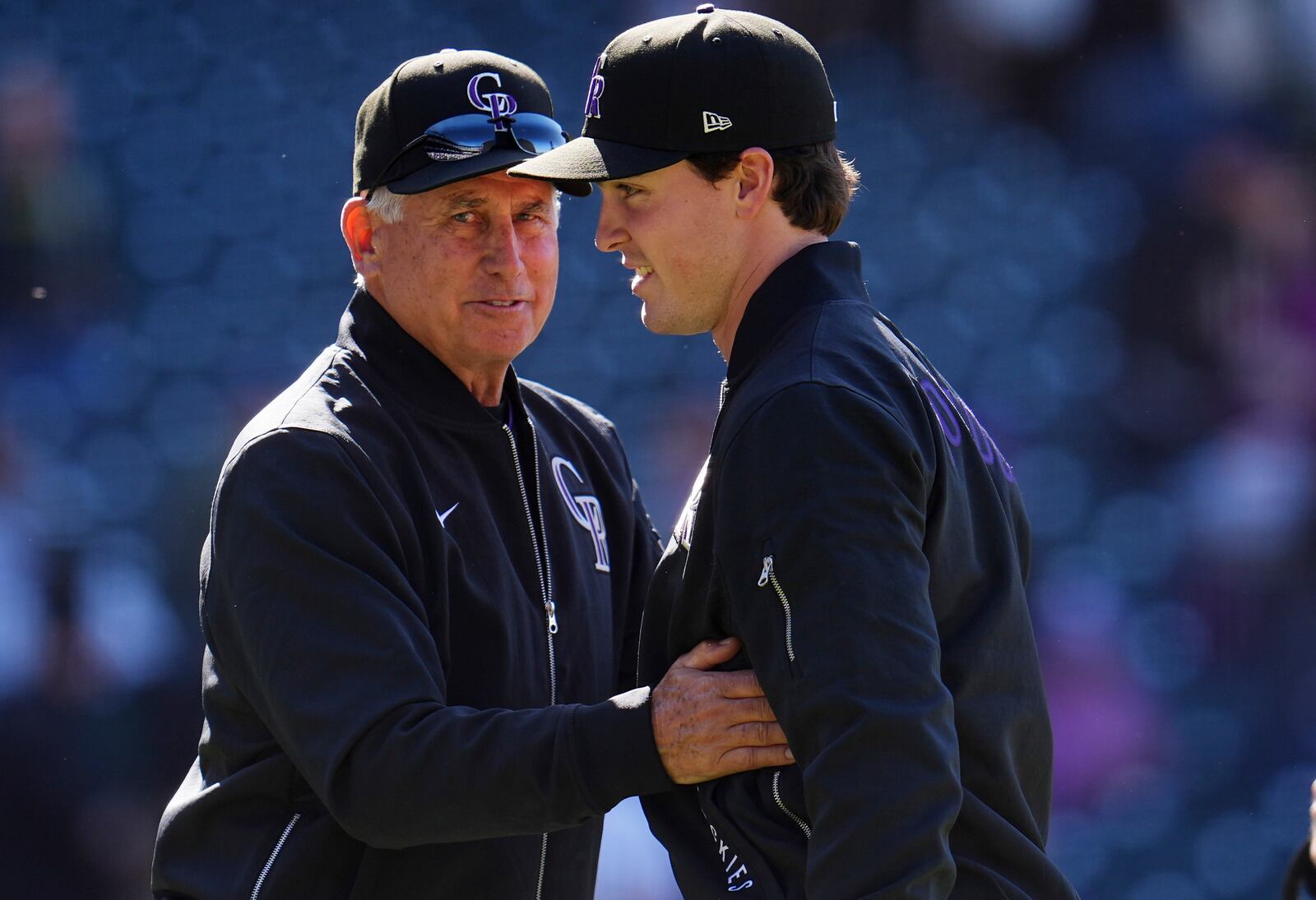 Colorado Rockies manager Bud Black, left, congratulates starting pitcher Chase Dollander after he posted a victory in his first major league start in a baseball game against the Athletics, Sunday, April 6, 2025, in Denver. (AP Photo/David Zalubowski)