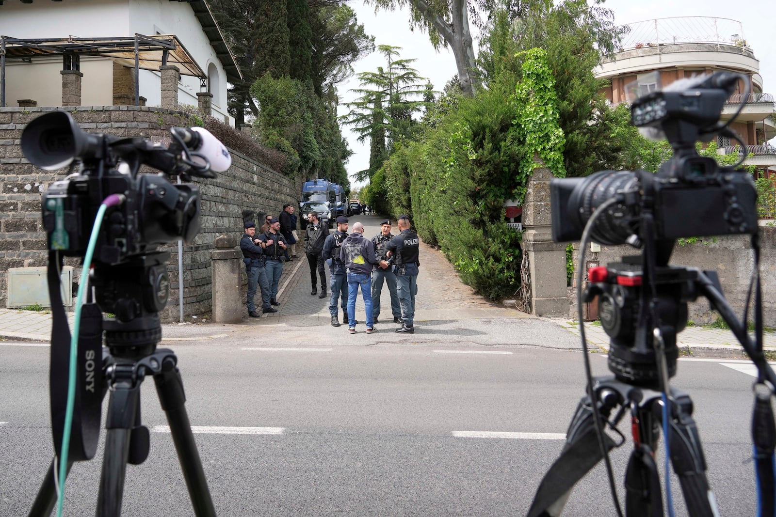 Police and reporters stand outside the Omani Embassy in Rome during a closed-door meeting between U.S. and Iranian delegations to discuss Tehran's rapidly advancing nuclear program, Saturday, April 19, 2025. (AP Photo/Andrew Medichini)
