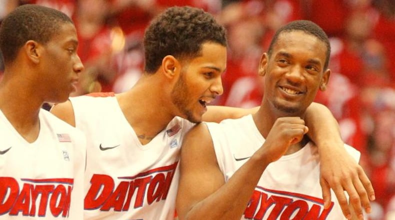 Dayton’s Jordan Sibert, left, Devin Oliver, center, and Dyshawn Pierre celebrate in the final seconds of a victory against Massachusetts on Saturday, March 1, 2014, at UD Arena. David Jablonski/Staff