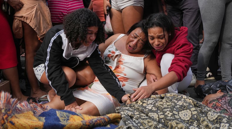Relatives mourn over the bodies of people killed the day before during a police raid targeting the Comando Vermelho gang in the Complexo da Penha favela of Rio de Janeiro, Brazil, Wednesday, Oct. 29, 2025. (AP Photo/Silvia Izquierdo)