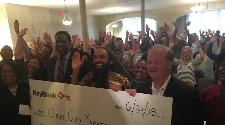 Supporters celebrate a $100,000 donation to the Gem City Market, which plans to be Dayton’s first food cooperative. STAFF/CORNELIUS FROLIK