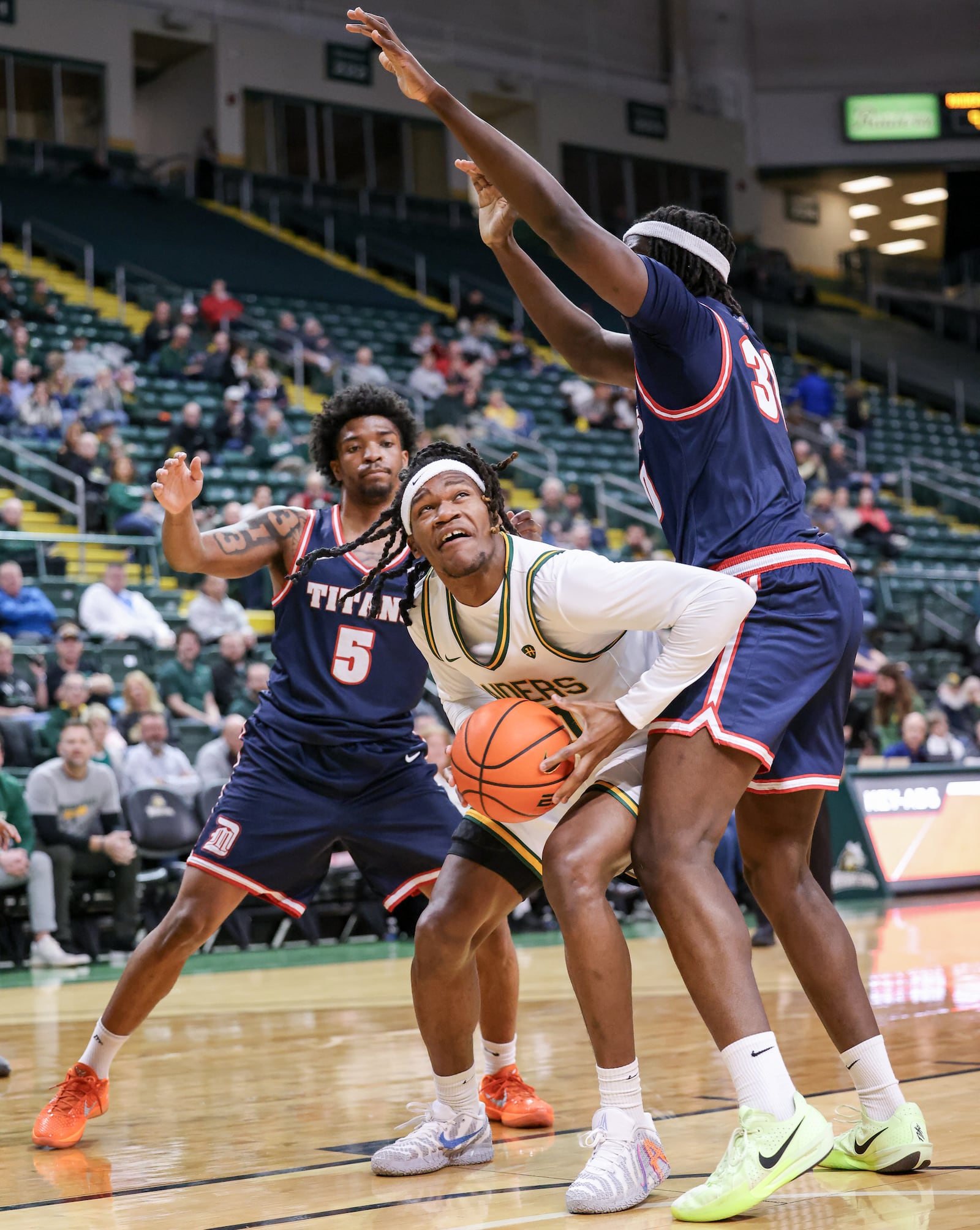 Wright State sophomore forward Andrea Holden (center) shoots with pressure from Detroit Mercy's Orlando Lovejoy (left) and Ryan Kalambay during a Horizon League game on Thursday, Feb. 12 at Ervin J. Nutter Center in Fairborn. BRYANT BILLING / STAFF
