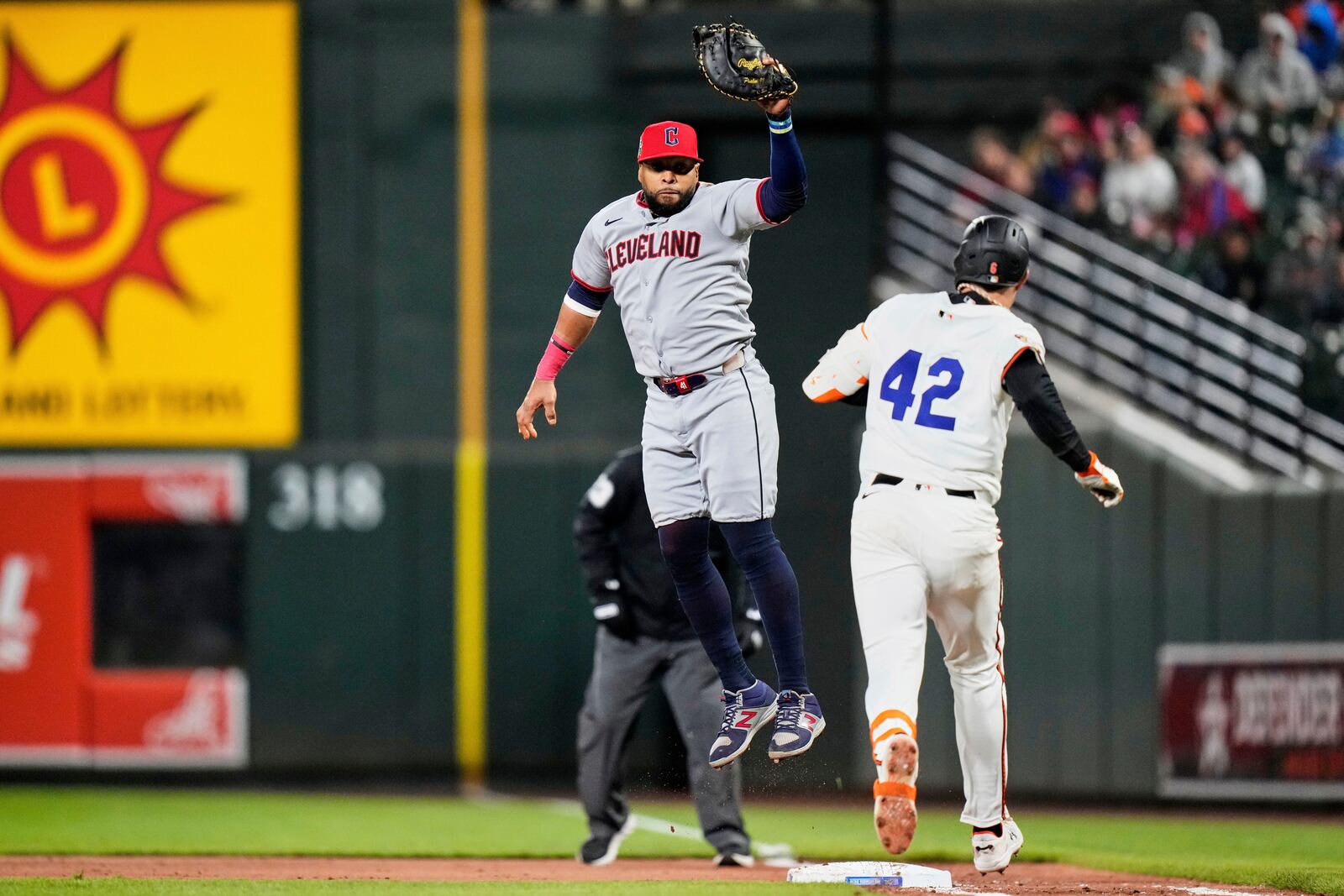 Baltimore Orioles' Ryan Mountcastle, right, reaches on a throwing error by Cleveland Guardians shortstop Brayan Rocchio as first baseman Carlos Santana, left, jumps but is unable to make the out during the fourth inning of a baseball game, Tuesday, April 15, 2025, in Baltimore. (AP Photo/Stephanie Scarbrough)