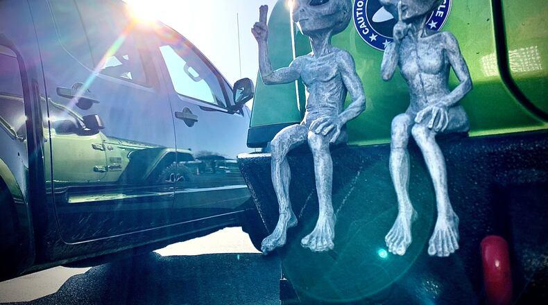 People came from far and wide to the National Museum of the United States Air Force, Monday, April 8, 2024 to view the eclipse. These two are sitting on the back bumper of a Jeep. MARSHALL GORBY \STAFF