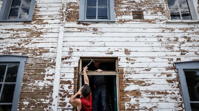 Carpenter Toby Arnold installs a transom window on the buggy whip building in downtown Tipp City Friday July 7, 2023. Jim Noelker/Staff
