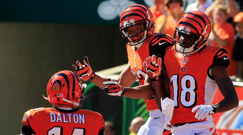 Cincinnati Bengals wide receiver A.J. Green (18) celebrates with wide receiver Mohamed Sanu (12) after Green caught a 20 yard touchdown pass from quarterback Andy Dalton (14) in the second half of an NFL football game against the Green Bay Packers, Sunday, Sept. 22, 2013, in Cincinnati. (AP Photo/Tom Uhlman)