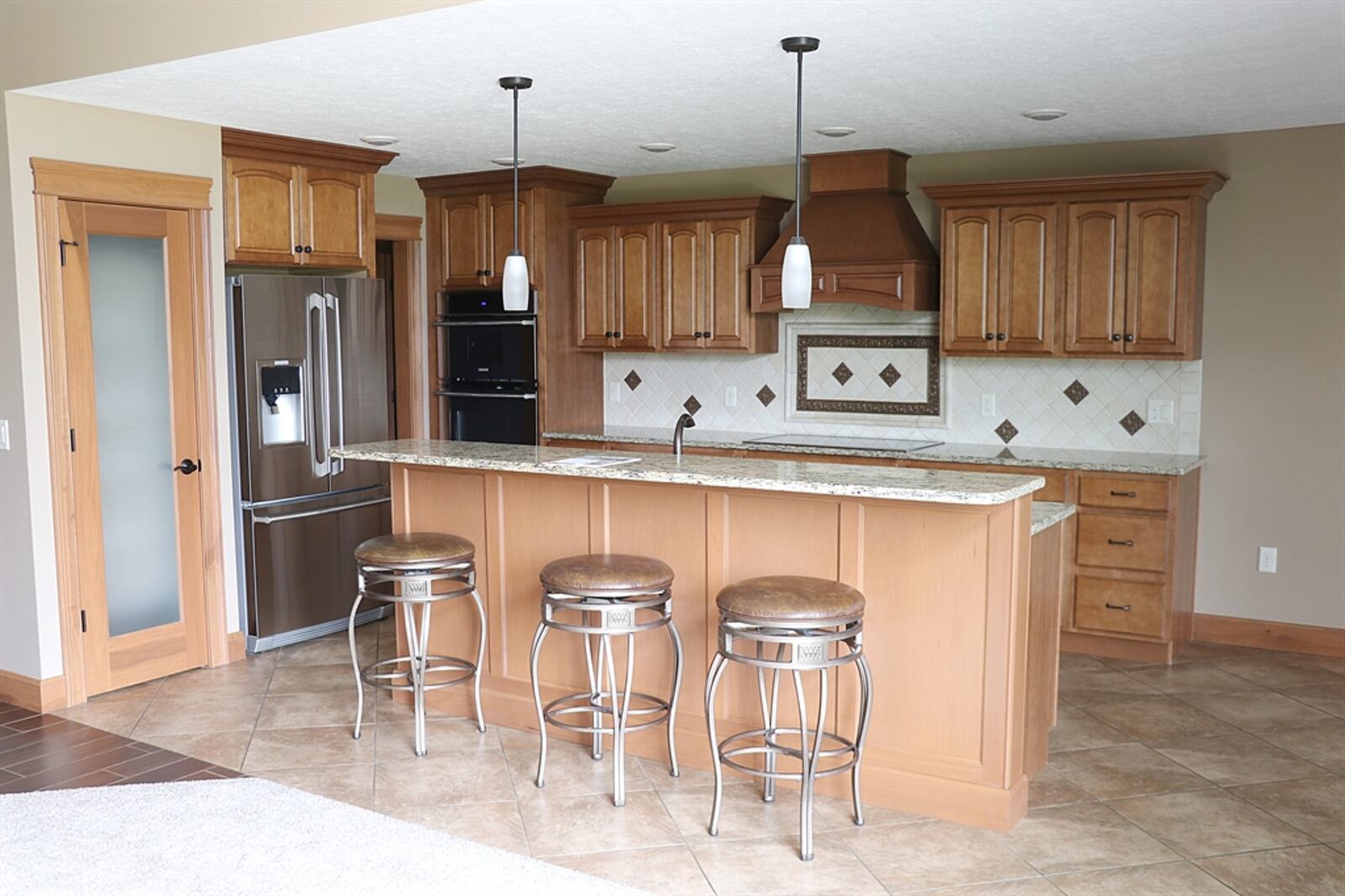 In the kitchen, a bi-level counter island offers bar seating and preparation space.