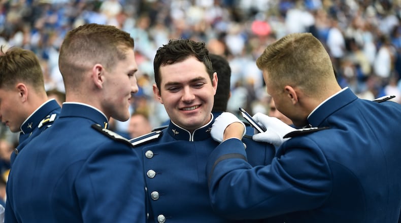 A Cadet gets help with his shoulder boards after graduation ceremonies during the United States Air Force Academy graduation ceremony Thursday, June 1, 2023, at Air force Academy, Colo. (AP Photo/John Leyba)