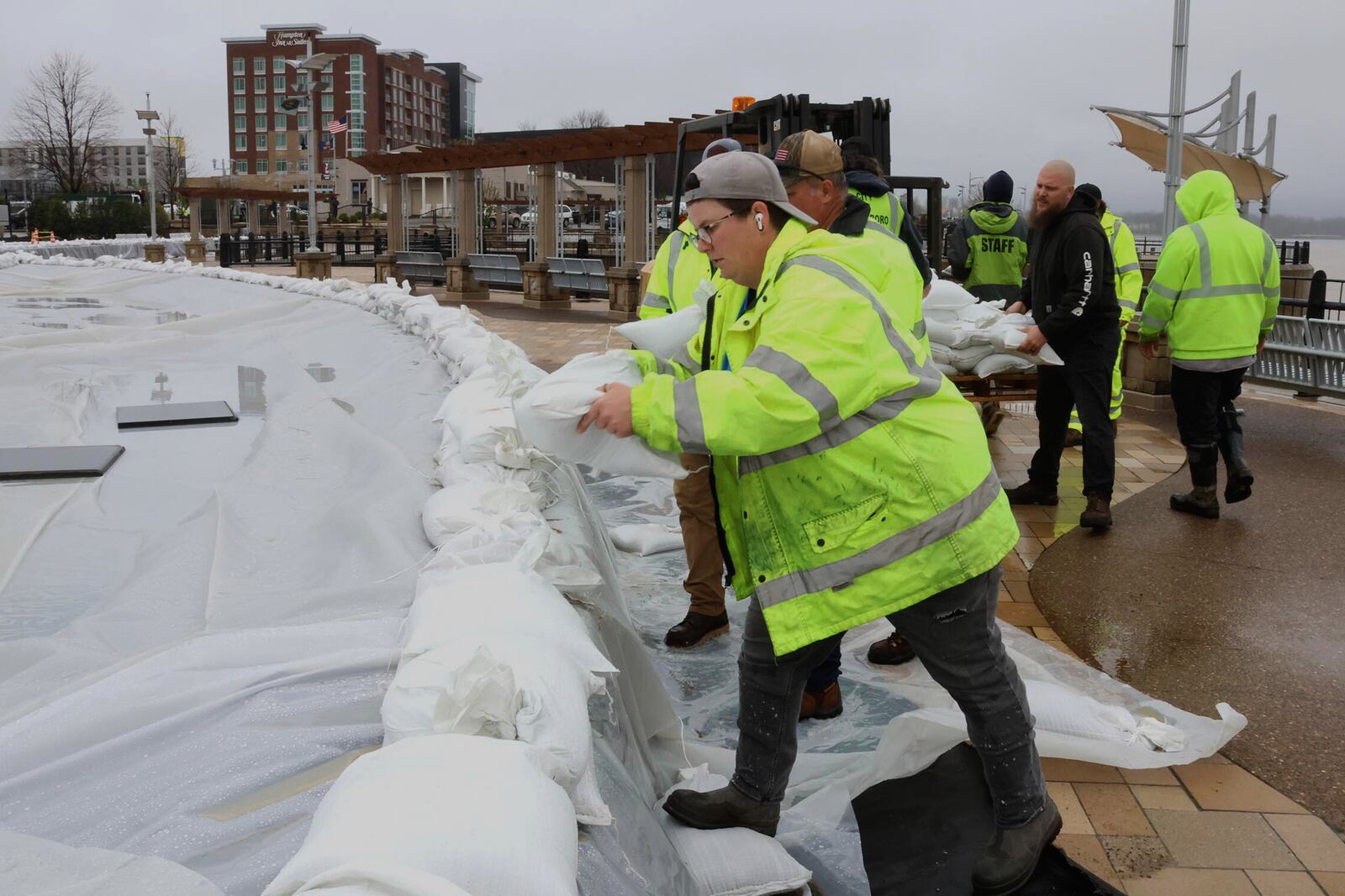 City of Owensboro workers put sandbags to protect the fountains in preparation for flooding of the Ohio River in Smothers Park in Owensboro, Ky., on Friday, April 4, 2025. (Alan Warren/The Messenger-Inquirer via AP)