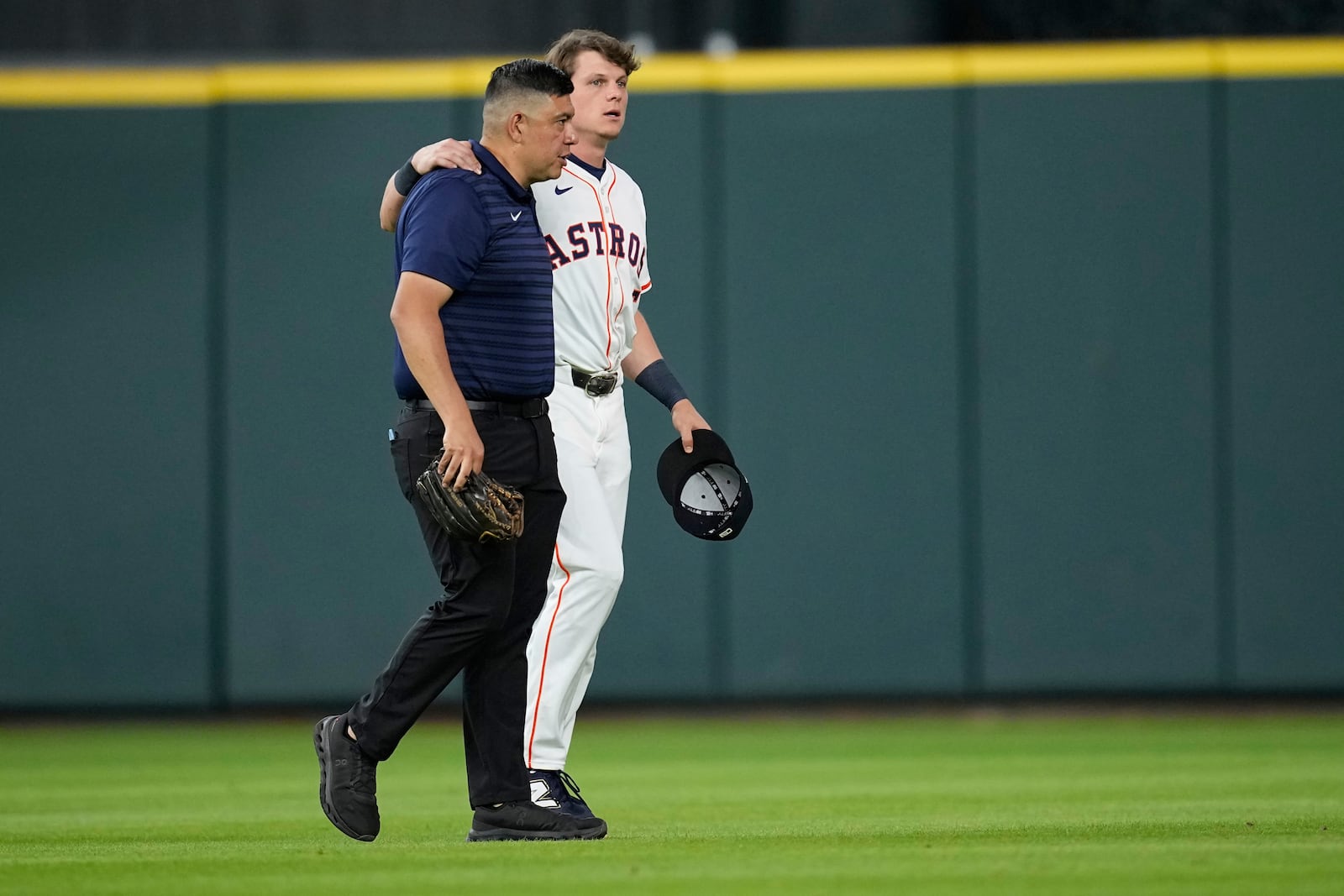 Houston Astros center fielder Jake Meyers, right, is helped off the field before the start of a baseball game against the Cleveland Guardians Wednesday, July 9, 2025, in Houston. (AP Photo/David J. Phillip)