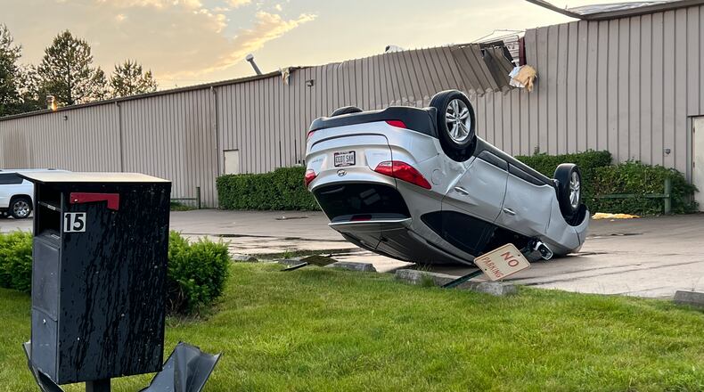 A car was flipped upside down and moved one parking spot over during Wednesday's tornado that tore through the area of Industrial Park Court in Tipp City. AIMEE HANCOCK/STAFF