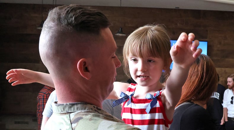 Calliope East gives her father, SSG Jacob East of the Ohio Army National Guard 1137th Tactical Installation Networking Enhanced Signal Company, a hug following a Call to Duty Ceremony for the unit Saturday, August 31, 2024 at the First Christian Church in Springfield. BILL LACKEY/STAFF