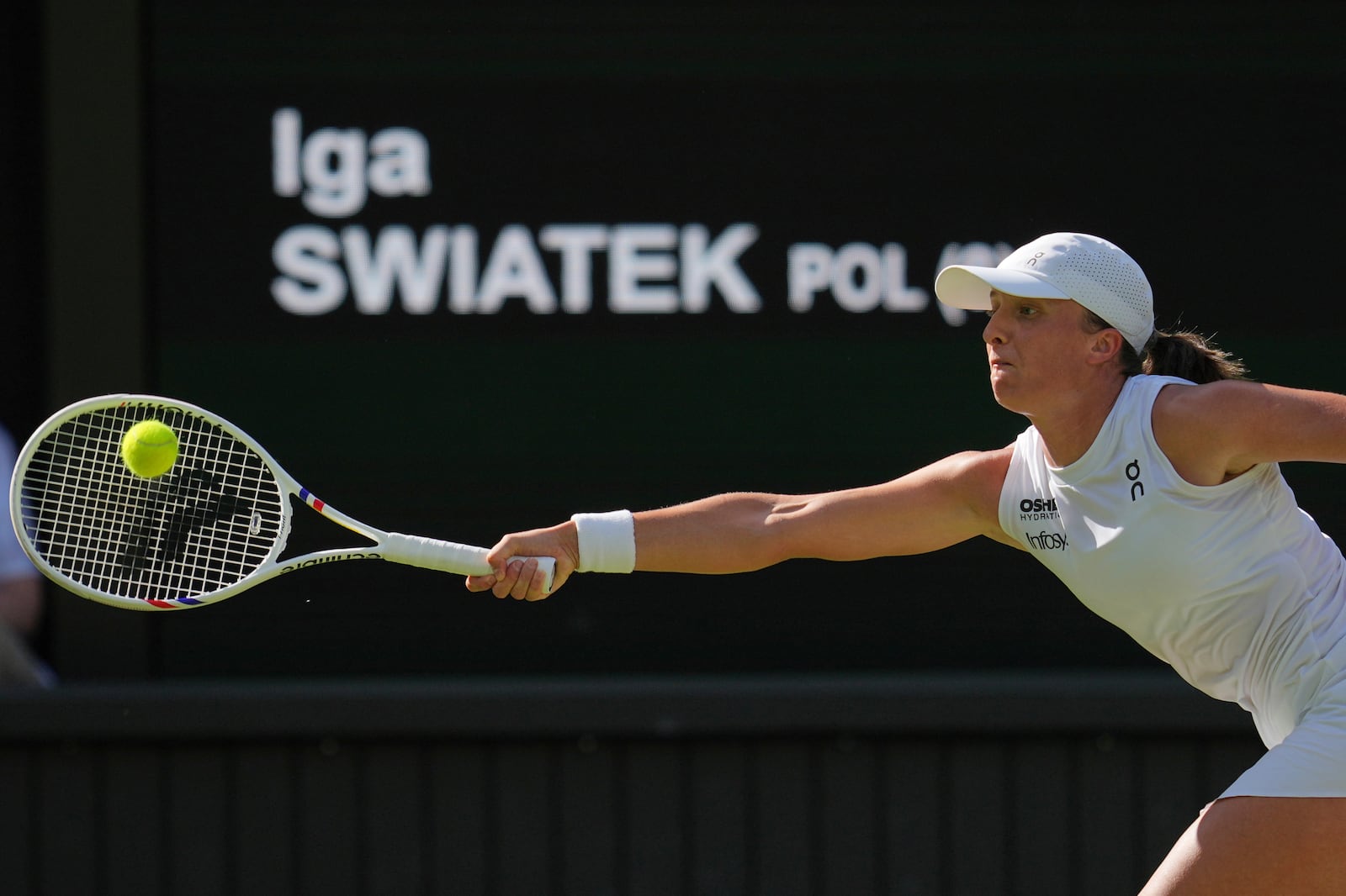 Poland's Iga Swiatek returns to Switzerland's Belinda Bencic during a women's singles semifinal match at the Wimbledon Tennis Championships in London, Thursday, July 10, 2025. (AP Photo/Kin Cheung)