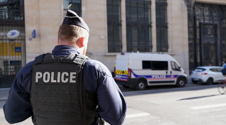 Police stand outside the Bank of America building in Paris, Saturday, March 28, 2026. (AP Photo/Nicolas Garriga)