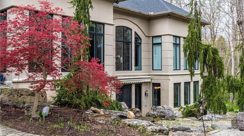 A stone-accented driveway encircles a raised tree garden to the double pillar accented formal entry to this ranch estate recently listed. Listed for $1,100,000 by Heather Fugate and Jon Murray of Better Homes and Gardens Real Estate Big Hill, the ranch at 7240 Meeker Creek in Butler Twp. has about 8,490 square feet of living space under majestic ceilings, picturesque windows and interesting architectural lines. Every room has a different ceiling treatment and nearly every room has a view of the 1.7-acre, wooded property. To see other listed homes, visit DaytonDailyNews.com/homes. PHOTOS COURTESY OF DAYTON REALTORS.