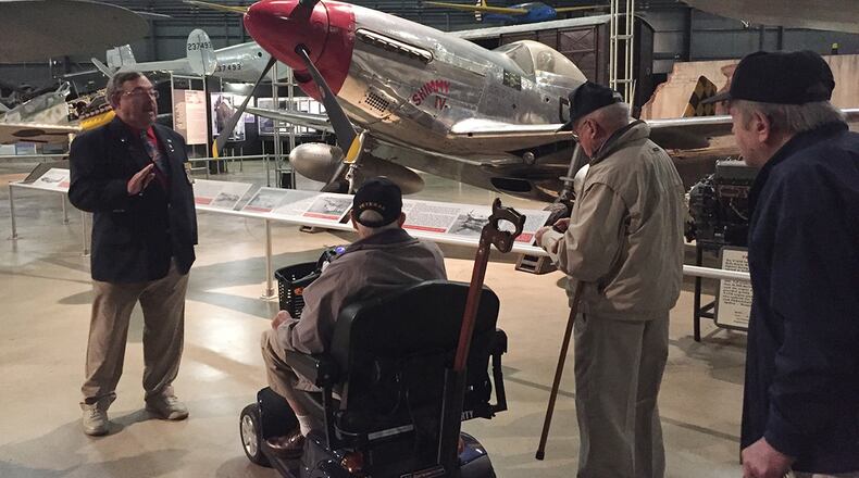 Wendell Miller, a docent at the National Museum of the U.S. Air Force, imparts facts about the North American P-51D Mustang fighter in the World War II Gallery to members of the Honoring Our Promises group Dec. 1. Eighteen area veterans enjoyed a tour and lunch, among them Larry Reynolds, WWII Army combat medic and liberator of Jewish concentration camp Gunskirchen Lager, on scooter; Air Force veteran Les Mills of Middletown; and William Wilmer, retired Air Force pilot. (Skywrighter photo/Amy Rollins)