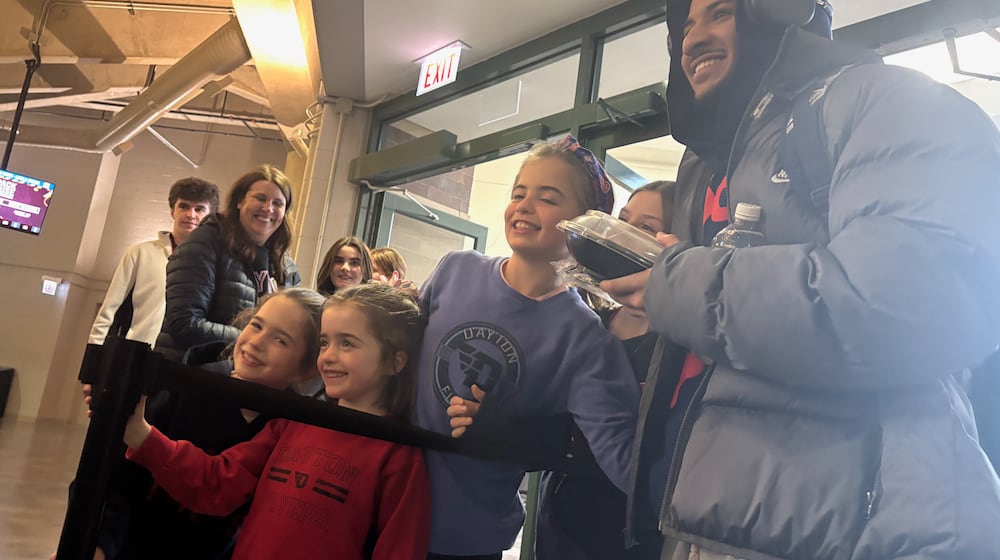 Dayton's Javon Bennett poses for a photo with fans after a victory against Loyola Chicago on Saturday, Jan. 3, 2026, at Gentile Arena. David Jablonski/Staff