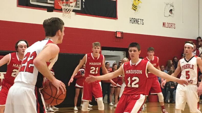 Madison’s Cameron Morgan (12) applies some defensive pressure to Preble Shawnee’s Austin Moore (22) on Friday night at Shawnee. RICK CASSANO/STAFF