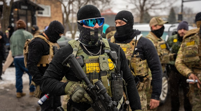 Federal agents stand guard, Wednesday, Jan. 21, 2026, in Minneapolis. (AP Photo/Angelina Katsanis)