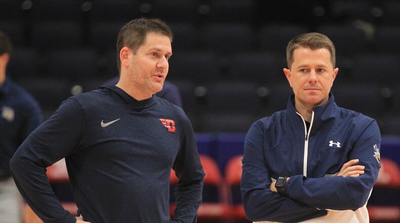 Dayton's Darren Hertz, left, talks to Cedarville's Pat Estepp before an exhibition game on Monday, Nov. 1, 2021, at UD Arena. David Jablonski/Staff