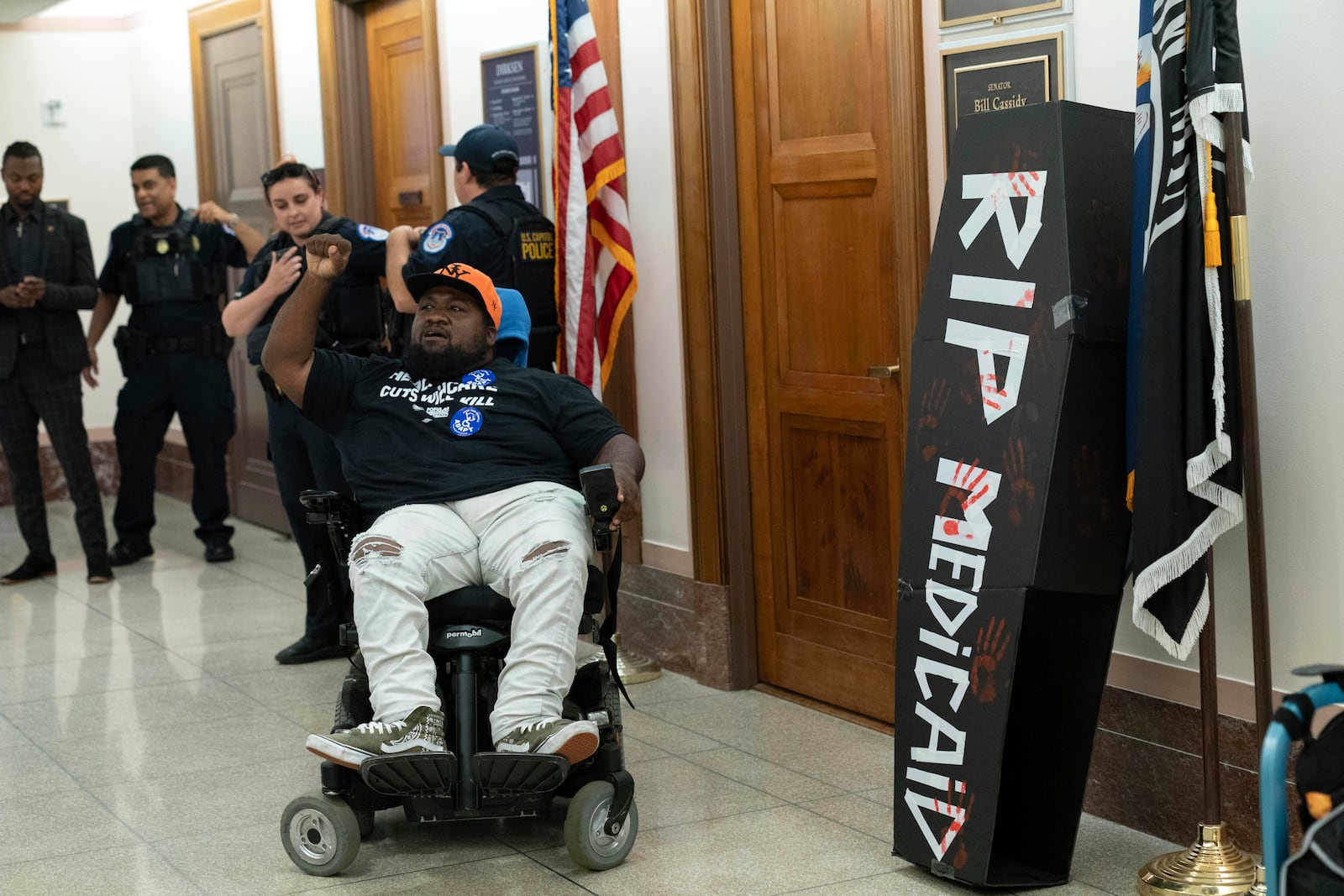 A demonstrator on wheelchair protests outside the office of Sen. Bill Cassidy, R-La., on the proposed cuts to Medicaid on Capitol Hill, in Washington, Wednesday, June 11, 2025. (AP Photo/Jose Luis Magana)